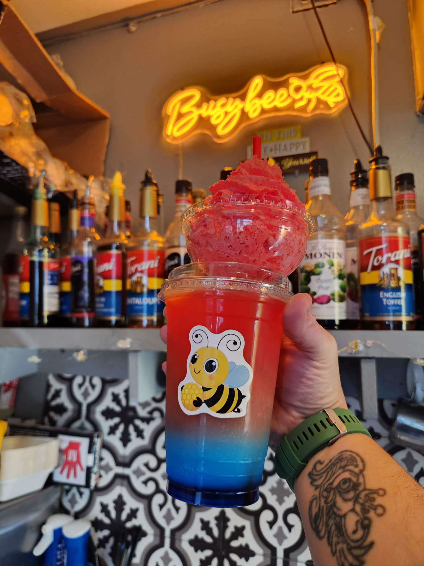 Red and blue layered Busy Bee Espresso slush topped with red whipped ice